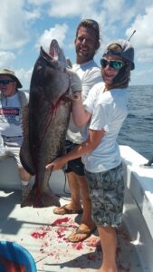 Two Couple Holding a Big Fish With Gut Cut