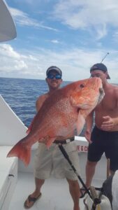 Two Men Holding Big Orange and White Color Fish